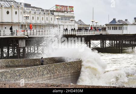 Brighton UK 3rd January 2022 - Wanderer fangen die Wellen am Brighton Palace Pier, während sie das windige Wetter am Neujahrsfeiertag in England genießen : Credit Simon Dack / Alamy Live News Stockfoto