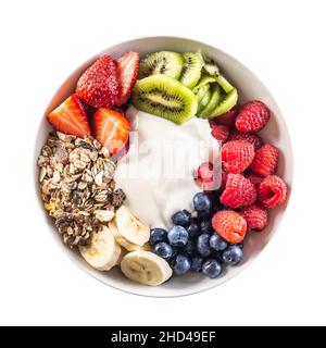 Draufsicht auf isolierte Obst- und Joghurtschüssel mit Müsli, Kiwi, Erdbeeren, Banane, Blaubeeren und Himbeeren. Stockfoto