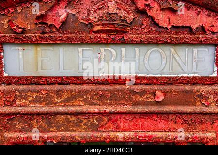 Ein vernachlässigter Telefon- und Briefkasten im schottischen Hochland, der dringend einer Neulackierung bedarf. Stockfoto