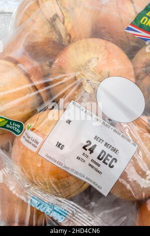 BRAUNE Zwiebeln/Allium cepa in Kunststoffpackungen. Auch als gelbe Zwiebeln + Best Before Date Label / BBD bezeichnet. Für gemeinsame Küchenzutaten & medizinische. Stockfoto