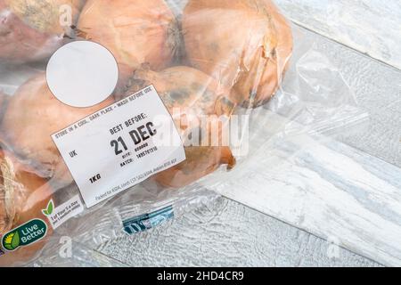 BRAUNE Zwiebeln/Allium cepa in Kunststoffpackungen. Auch als gelbe Zwiebeln + Best Before Date Label / BBD bezeichnet. Für gemeinsame Küchenzutaten & medizinische. Stockfoto