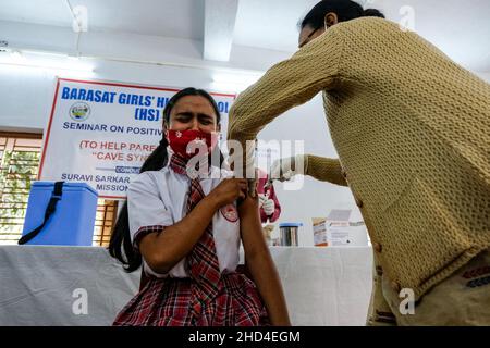 Kalkutta, Indien. 03rd Januar 2022. Ein Gesundheitsmitarbeiter verabreicht einer Schülerin der Barasat Girls High School, Kalkutta, eine Dosis Covaxin-Impfstoff, die von Bharat Biotech entwickelt wurde.Angesichts des enormen Anstiegs der COVID-19-Fälle in Westbengalen beginnt am 3rd. Januar die Impfkampagne für Menschen der Altersgruppe von 15-18 Jahren. Kredit: SOPA Images Limited/Alamy Live Nachrichten Stockfoto