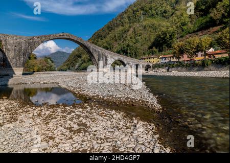 Der Fluss Serchio fließt unter der alten Ponte della Maddalena, Borgo a Mozzano, Lucca, Italien Stockfoto