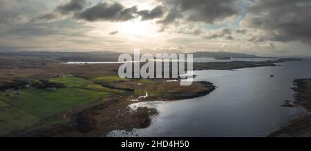 Luftaufnahme der Isle of Skye mit dramatischen Wolken und Wetter, ein Bauernhaus auf einer kleinen Insel, umgeben von Wasser Stockfoto