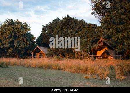 Die Sonne geht über der Unterkunft im Safarizelt im Flatdogs Camp im South Luangwa National Park, Sambia, auf Stockfoto