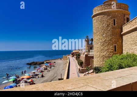 Schloss von Santa Ana mit dem Ufer des Strandes voller Menschen, Roquetas de Mar, Almeria, Andalusien, Spanien. Stockfoto