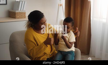 Fürsorgliche Schwarze Mutter Lehrt Ihren Kleinen Sohn, Der Zu Hause Auf Den Fingern Zählt Stockfoto