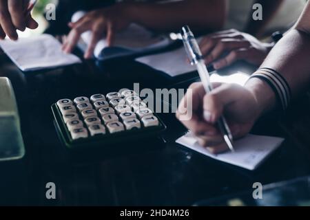 KORONADAL, PH – 25. DEZEMBER 2021: Hände von Spielern auf dem Tisch, die das beliebte Boggle-Spiel aus den 5x5-er Jahren spielen. Selektiver Fokus. Stockfoto