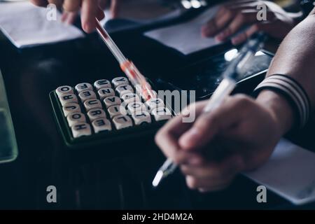 KORONADAL, PH – 25. DEZEMBER 2021: Hände von Spielern auf dem Tisch, die das beliebte Boggle-Spiel aus den 5x5-er Jahren spielen. Selektiver Fokus. Stockfoto