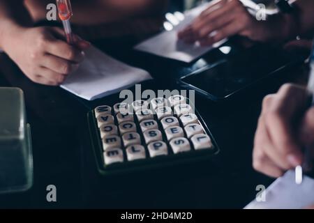 KORONADAL, PH – 25. DEZEMBER 2021: Hände von Spielern auf dem Tisch, die das beliebte Boggle-Spiel aus den 5x5-er Jahren spielen. Selektiver Fokus. Stockfoto