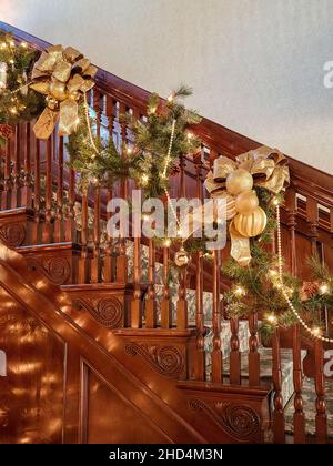 Home Innenraum Weihnachtslichter und ausgefallene Golddekorationen auf einer Holztreppe Stockfoto