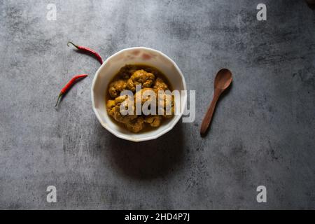 Gobi Masala, ein gerösteter Blumenkohl oder ein Schälchen, serviert in einer weißen Schüssel. Draufsicht. Stockfoto