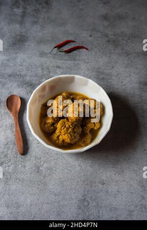 Gobi Masala, ein gerösteter Blumenkohl oder ein Schälchen, serviert in einer weißen Schüssel. Draufsicht. Stockfoto