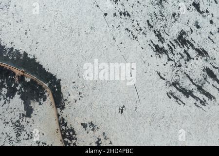 Abgebrochene weiße Farbe auf zerkratztem Glas. Abstrakter Hintergrund mit Copyspace. Stockfoto