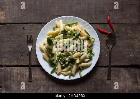 Italienische Delikatesse Penne Pasta in Käsesauce auf einem Teller. Draufsicht. Stockfoto