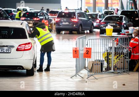 Stuttgart, Deutschland. 03rd Januar 2022. Malteser-Mitarbeiter geimpften in einer Halle der Messe Stuttgart Menschen gegen das Corona-Virus. Unter dem Motto "Wir impfen DAS LAND - Teil II" findet vom 03. Bis 06. Januar 2022 in der Messe Stuttgart eine Drive-in-Impfkampagne statt, bei der sich Interessierte von 7 bis 11 Uhr in der Messehalle 9 impfen lassen können. Quelle: Christoph Schmidt/dpa/Alamy Live News Stockfoto