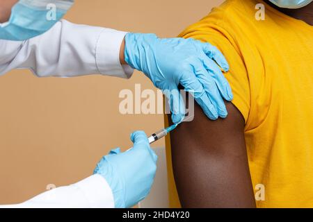 Impfprozess. Unkenntlich Arzt Macht Injektion Zu Schwarzen Männlichen Patienten Stockfoto