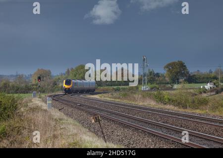 Crosscountry Train mit einem Gefahrensignal dahinter wird das Signal automatisch auf Gefahr gesetzt, wenn der Zug vorbeifährt, Stoke Orchard, Gloucestershire, UK Stockfoto