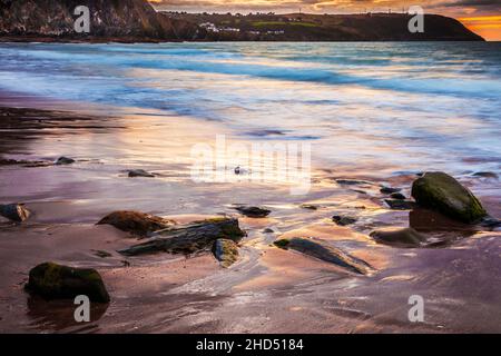 Sonnenuntergang über dem Strand von Tresaith in Ceredigion mit Blick auf Aberporth. Stockfoto