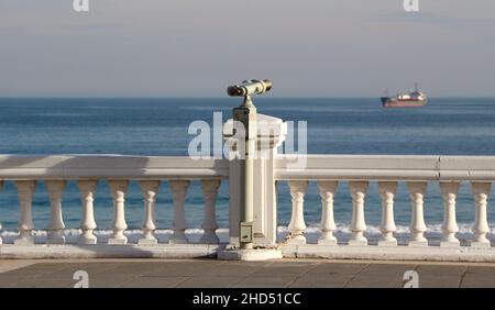 Münzbetriebenes Metall Tower Viewer Fernglas auf einem Stiel am Meer mit Blick auf das Meer auf einem verankerten Schiff Sardinero Santander Cantabria Spanien Stockfoto