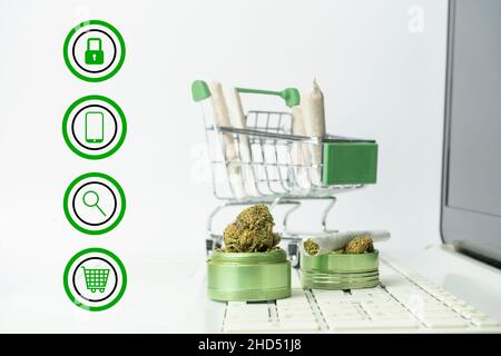 Marihuana und medizinisches Cannabis Online-Shopping-Konzept.Marihuana-Unkrautknospen und Gelenke im Warenkorb auf Laptop Stockfoto