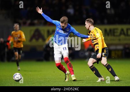 Ronan Curtis von Portsmouth (links) und Adam May von Cambridge United kämpfen während des Sky Bet League One-Spiels im Abbey Stadium, Cambridge, um den Ball. Bilddatum: Montag, 3. Januar 2022. Stockfoto