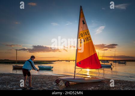 Teenagerjunge, der nach einem abendlichen Segeltörn ein Beiboot zurückholen konnte. Stockfoto