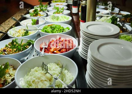 Restaurant mit frischen und biologischen Salaten. Selbstbedienungsessen in einem Einkaufszentrum. Salatgerichte auf der Theke beim Catering-Service vom Buffet Stockfoto