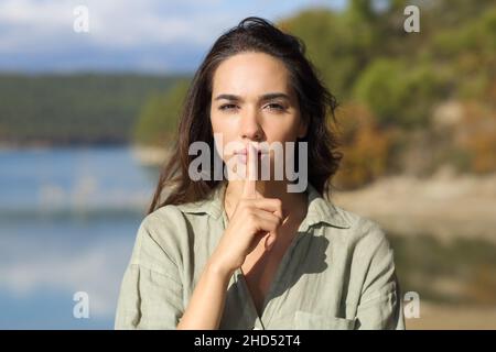 Vorderansicht Porträt einer ernsthaften Frau, die in einem See um Ruhe bittet Stockfoto