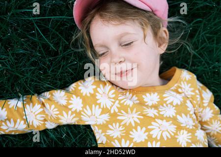 Mädchen mit roten Haaren, die auf Gras liegen Stockfoto