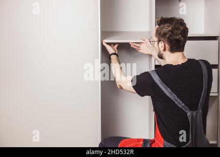 Möbelmonteur montiert moderne Schiebetürschrank Stockfoto