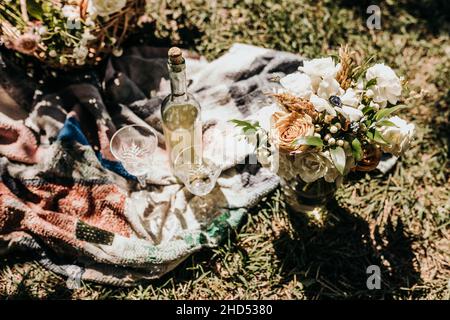 Picknick mit Wein und einem frischen Blumenstrauß an einem sonnigen Tag Stockfoto