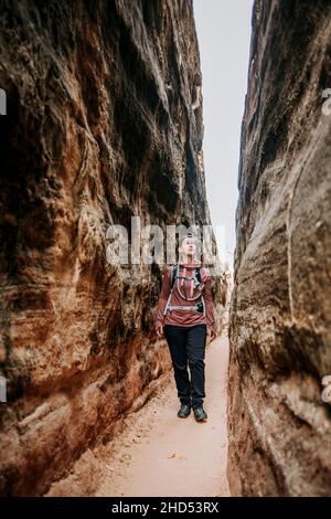 Weibliche Wanderer wandern durch Slot Canyon, Needles, Canyonlands Utah Stockfoto