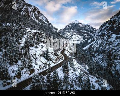 Verschneite Straße schlängelt sich durch Berge, Red Mountain Pass, Colorado Stockfoto