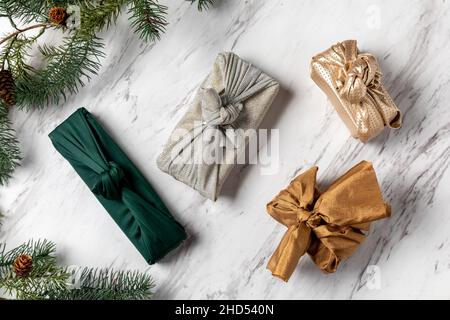 Geschenke in Stoffverpackung auf Marmor Stockfoto