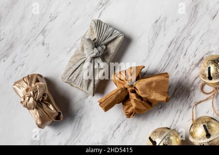 Weihnachtsgeschenke in Stoffverpackung auf Marmor Stockfoto