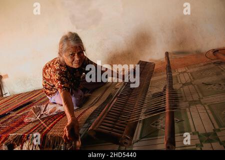 Alte Frau, die traditionelle Sedge Matten in Duy Vinh Village, Vietnam, webt Stockfoto