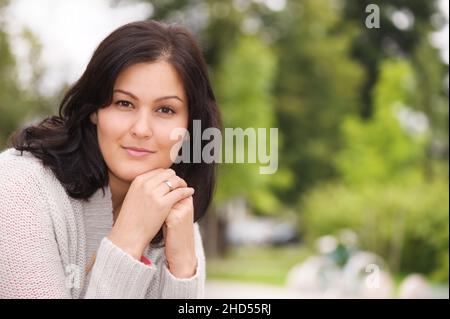Schöne junge Frau, die die Kamera anschaut. Selektiver Fokus und geringe Schärfentiefe. Stockfoto