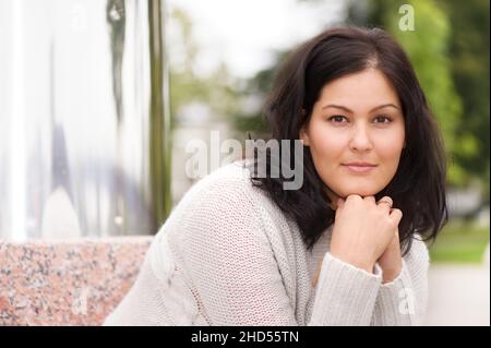 Schöne junge Frau, die die Kamera anschaut. Selektiver Fokus und geringe Schärfentiefe. Stockfoto