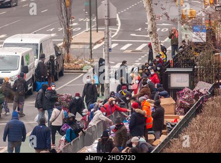 Am Heiligabend, dem 24. Dezember 2021, verteilen Freiwillige Kleidung, Decken und andere Ausstattungen für die Obdachlosen und Armen vor der Church of the Holy Apostles in Chelsea in New York. (© Richard B. Levine) Stockfoto