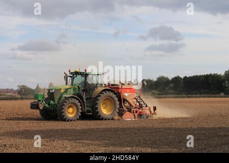 Garforth in der Nähe von Leeds West Yorkshire, Großbritannien 18th. Juli 2021 Bauer pflügt und sät ein Feld mit Traktor und Sämaschine an einem Sommermorgen Stockfoto