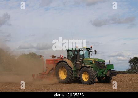 Garforth in der Nähe von Leeds West Yorkshire, Großbritannien 18th. Juli 2021 Bauer pflügt und sät ein Feld mit Traktor und Sämaschine an einem Sommermorgen Stockfoto