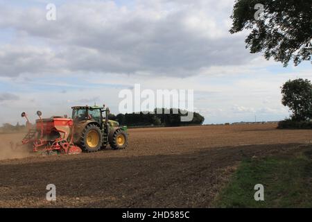 Garforth in der Nähe von Leeds West Yorkshire, Großbritannien 18th. Juli 2021 Bauer pflügt und sät ein Feld mit Traktor und Sämaschine an einem Sommermorgen Stockfoto