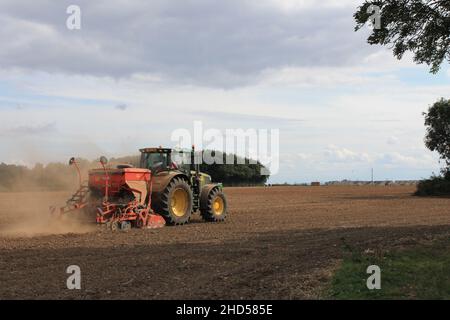 Garforth in der Nähe von Leeds West Yorkshire, Großbritannien 18th. Juli 2021 Bauer pflügt und sät ein Feld mit Traktor und Sämaschine an einem Sommermorgen Stockfoto