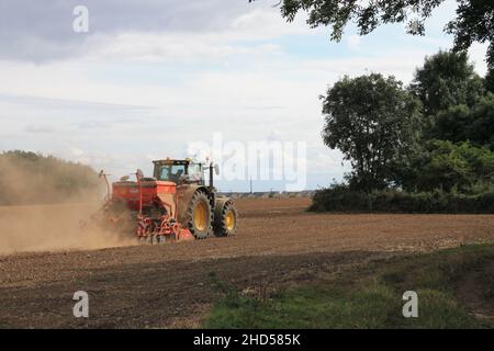 Garforth in der Nähe von Leeds West Yorkshire, Großbritannien 18th. Juli 2021 Bauer pflügt und sät ein Feld mit Traktor und Sämaschine an einem Sommermorgen Stockfoto