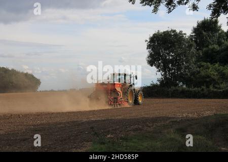 Garforth in der Nähe von Leeds West Yorkshire, Großbritannien 18th. Juli 2021 Bauer pflügt und sät ein Feld mit Traktor und Sämaschine an einem Sommermorgen Stockfoto