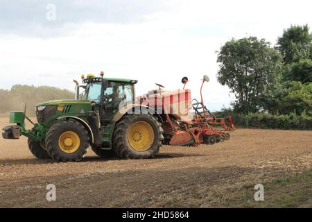 Garforth in der Nähe von Leeds West Yorkshire, Großbritannien 18th. Juli 2021 Bauer pflügt und sät ein Feld mit Traktor und Sämaschine an einem Sommermorgen Stockfoto