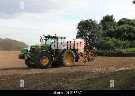 Garforth in der Nähe von Leeds West Yorkshire, Großbritannien 18th. Juli 2021 Bauer pflügt und sät ein Feld mit Traktor und Sämaschine an einem Sommermorgen Stockfoto