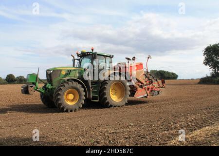 Garforth in der Nähe von Leeds West Yorkshire, Großbritannien 18th. Juli 2021 Bauer pflügt und sät ein Feld mit Traktor und Sämaschine an einem Sommermorgen Stockfoto