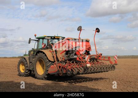 Garforth in der Nähe von Leeds West Yorkshire, Großbritannien 18th. Juli 2021 Bauer pflügt und sät ein Feld mit Traktor und Sämaschine an einem Sommermorgen Stockfoto